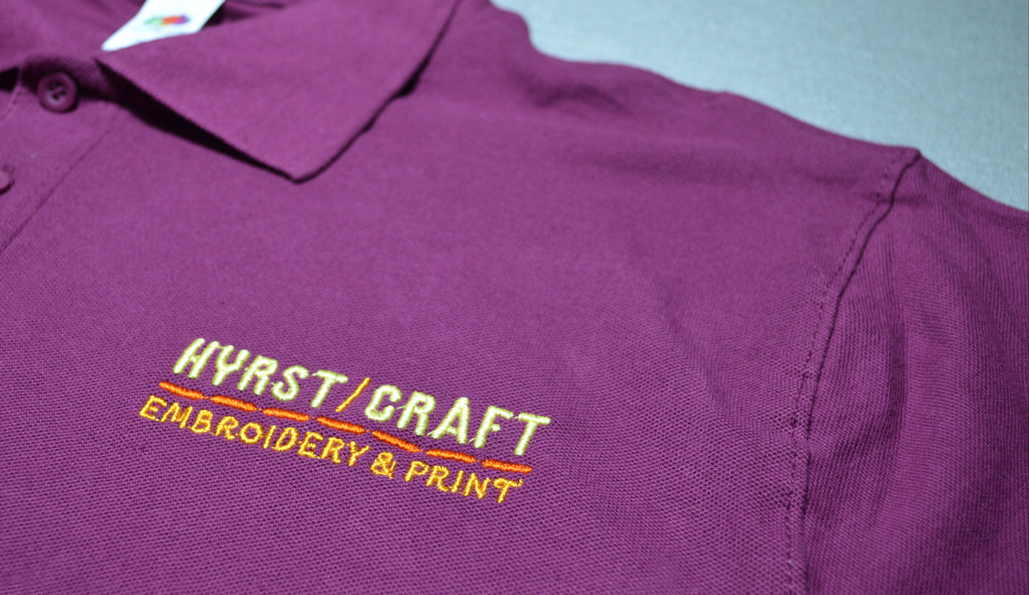 Purple polo shirt with 'Hyrstcraft Embroidery & Print' logo on a light blue background